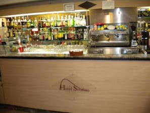 A bar area with a variety of bottles and a coffee machine. - Hotel Serafino (Genoa)