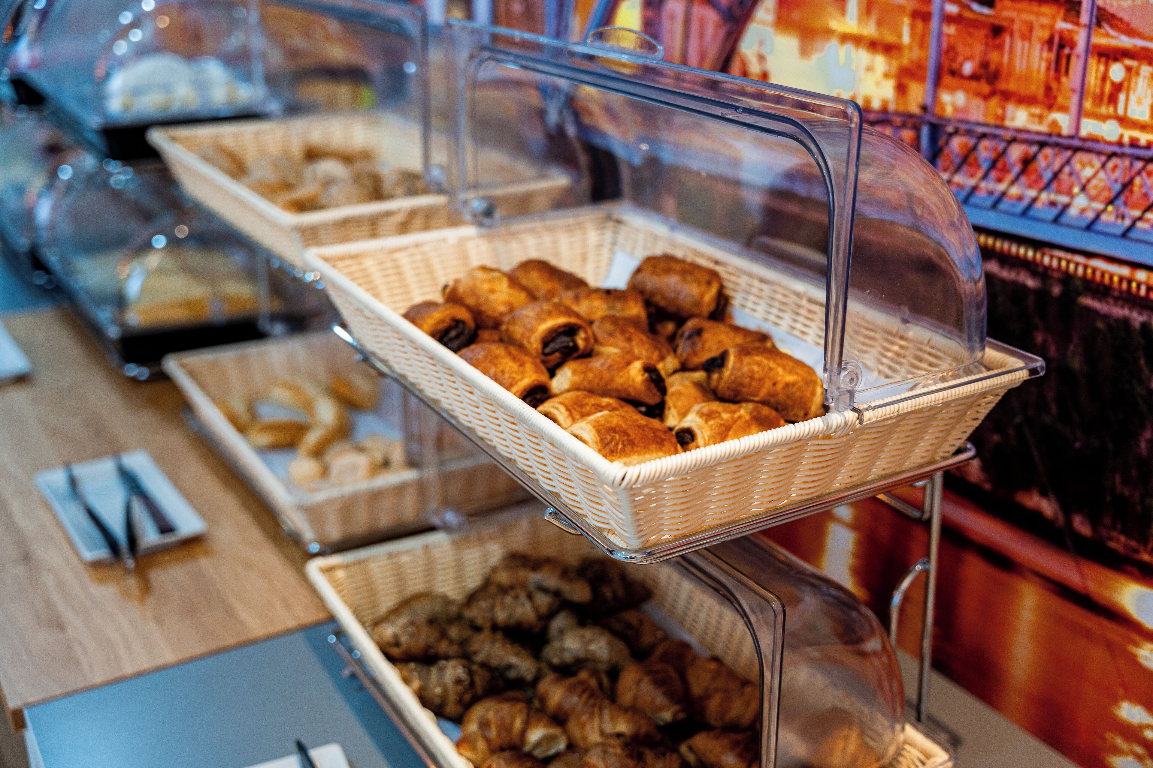 Un buffet proposant une variété de produits de boulangerie présentés dans des paniers en osier.