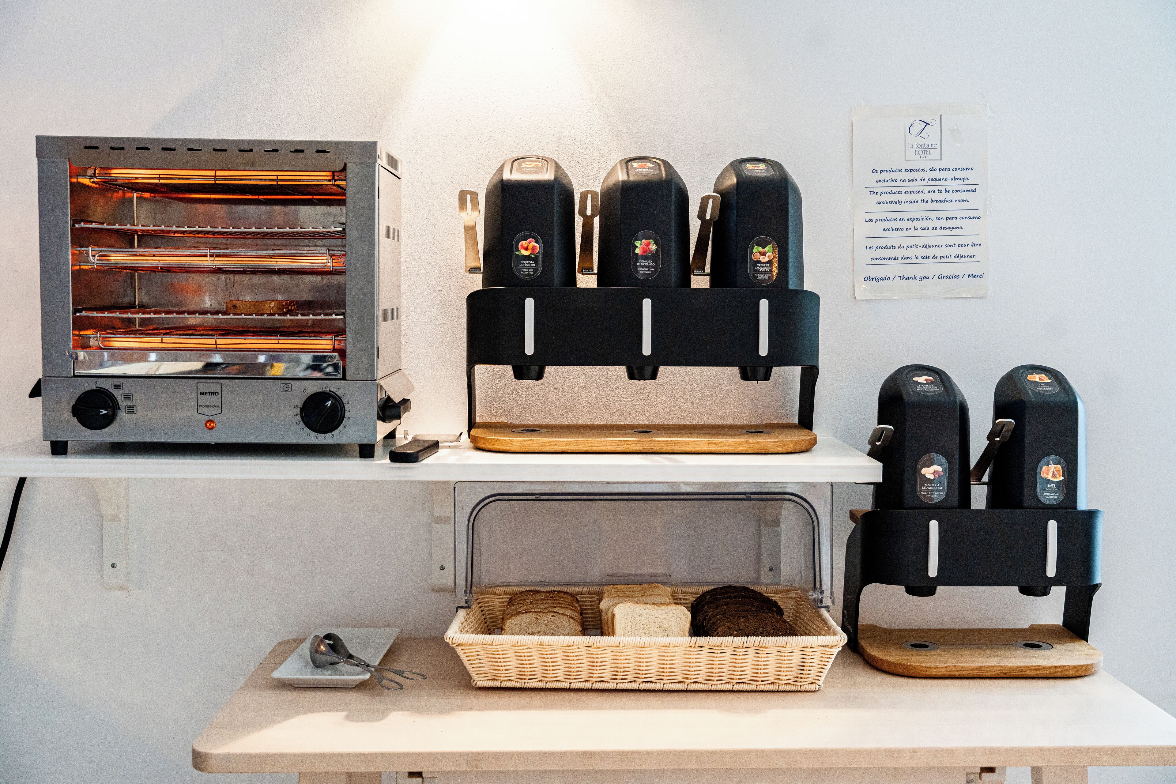 Een keukenhoek met een broodoven, koffiezetapparaten en een mand met brood.