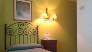 A room with a bed, a nightstand with a lamp, and a framed picture on the wall. - Maestre (Córdoba)