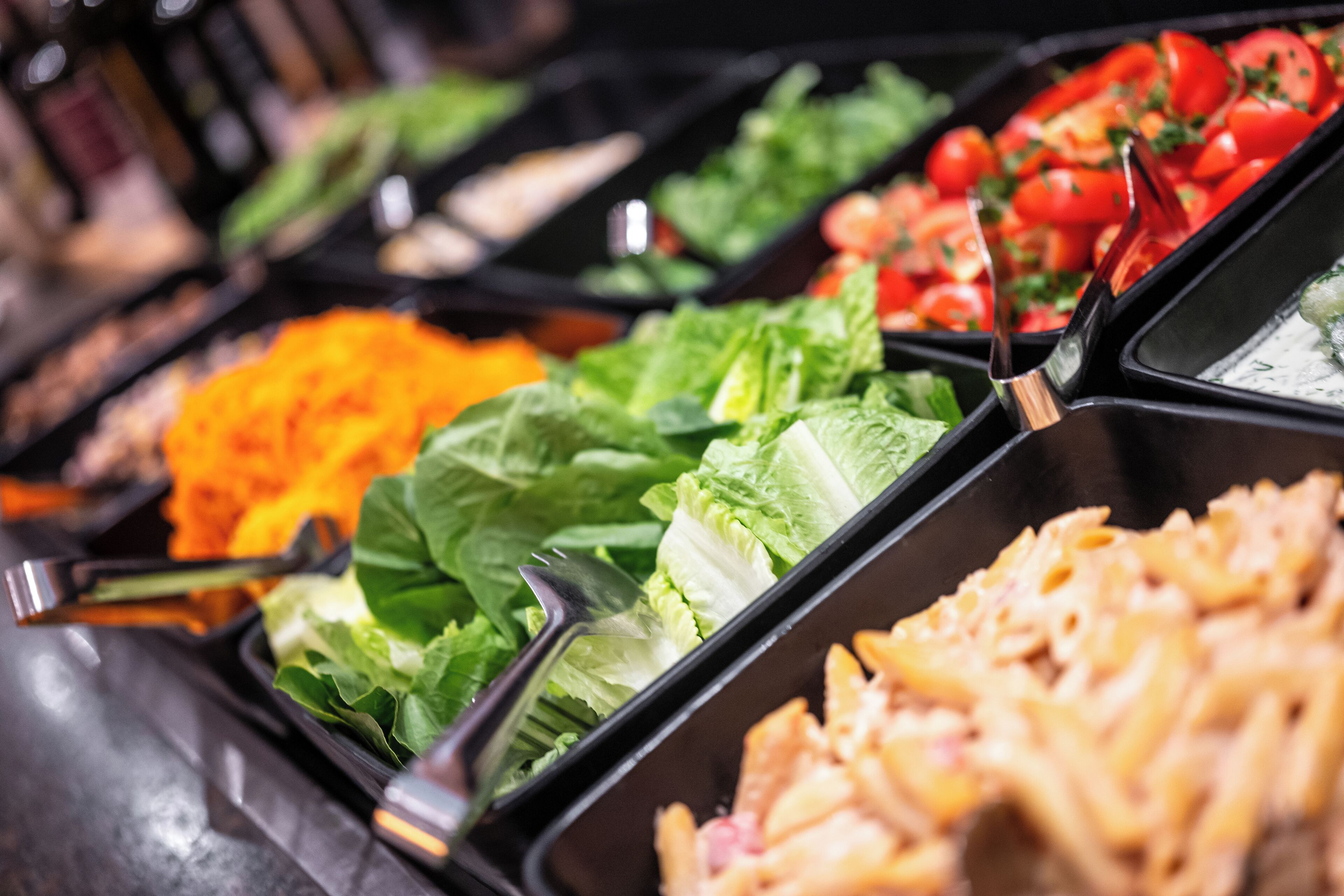 Een buffet met diverse keuzes, zoals pasta, salades en groenten.