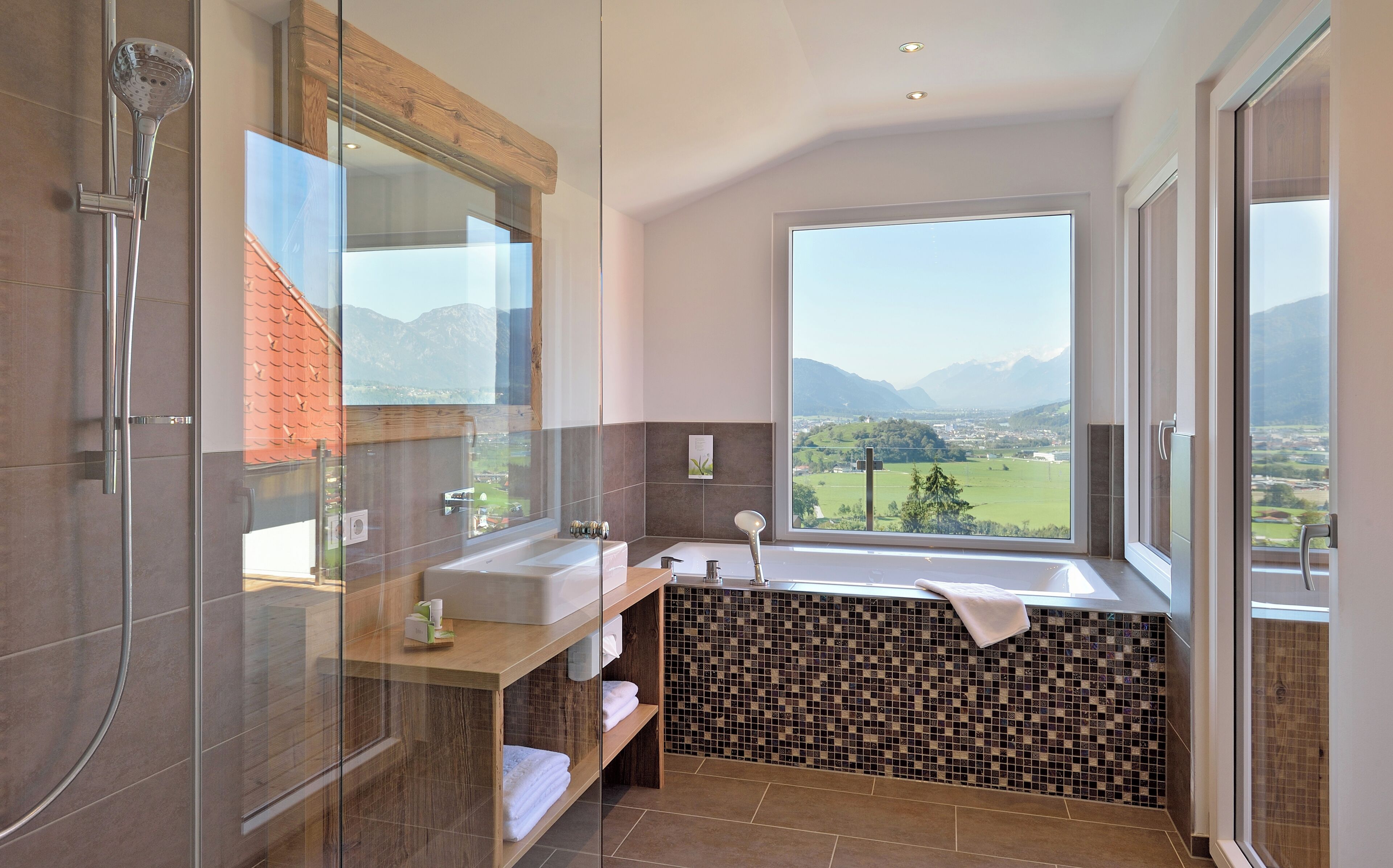 A modern bathroom with a glass-enclosed shower, a sink, and a bathtub.