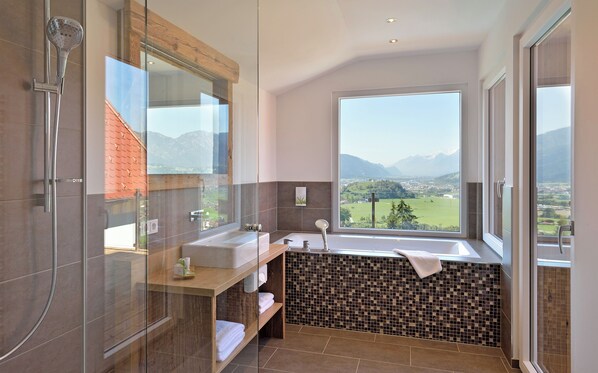 Un baño moderno con ducha envuelta en vidrio, lavabo y bañera.
