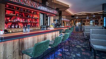 A bar area with wooden shelves, green bar stools, and a patterned carpet.