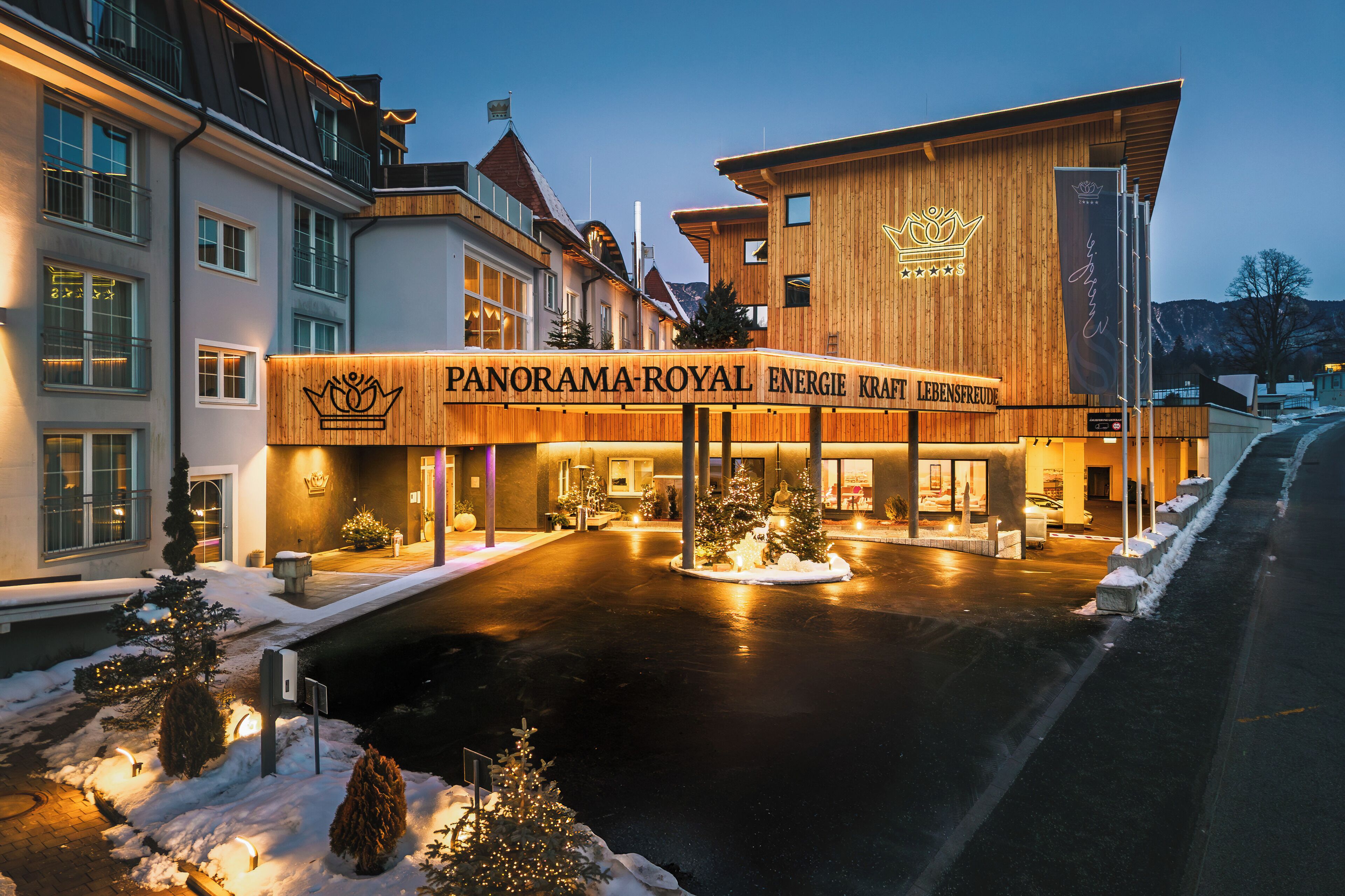 Et hotel med et tydeligt skilt, der viser "PANORAMA-ROYAL ENERGIE KRAT LEBENSFREUDE", og en træfacade.