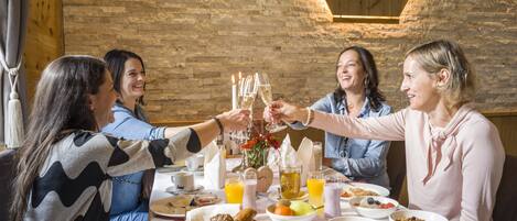 Un grupo de personas brindando en una mesa con alimentos y bebidas para el desayuno.