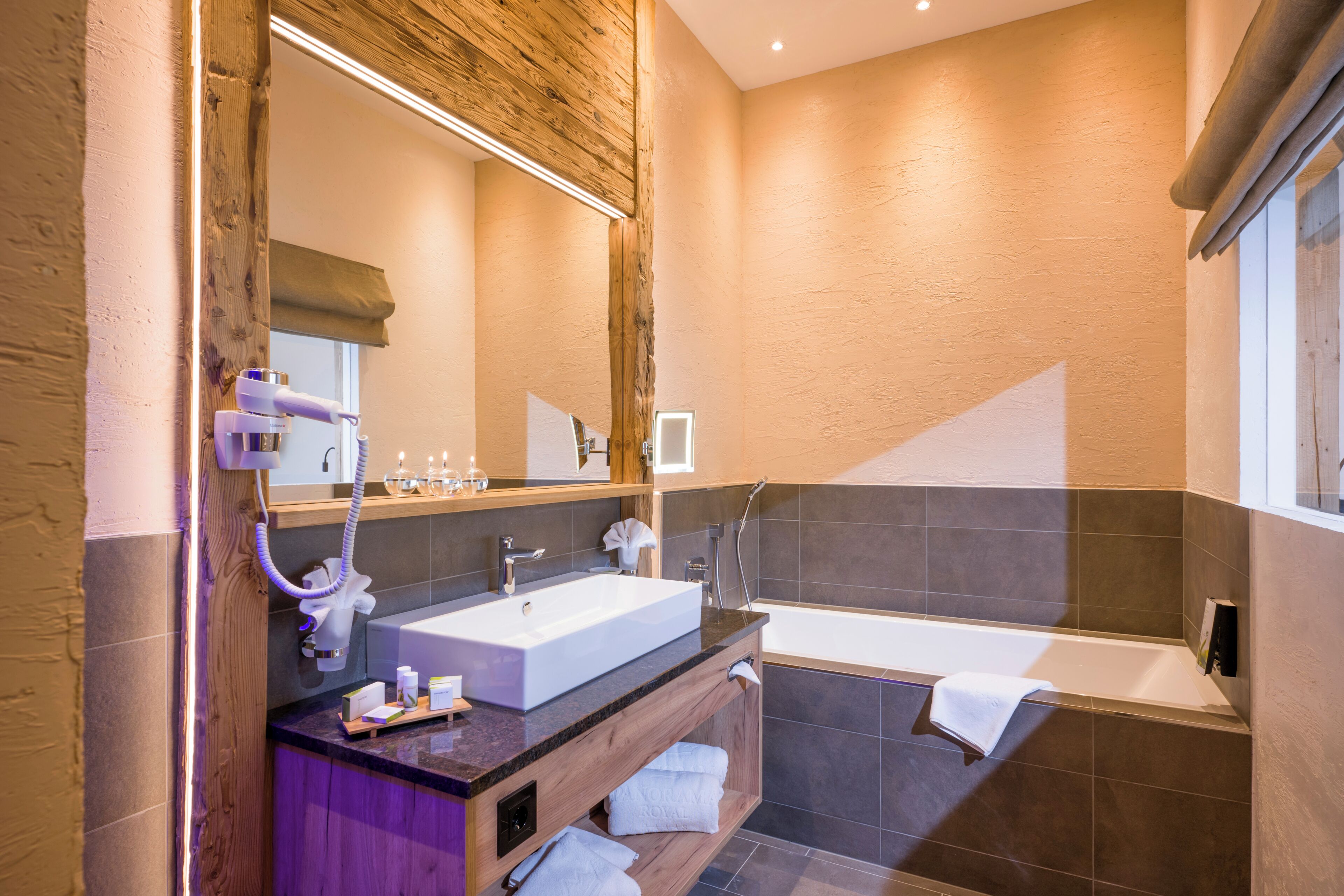 Une salle de bain moderne avec un grand lavabo, une baignoire et un meuble-lavabo doté d’un miroir.