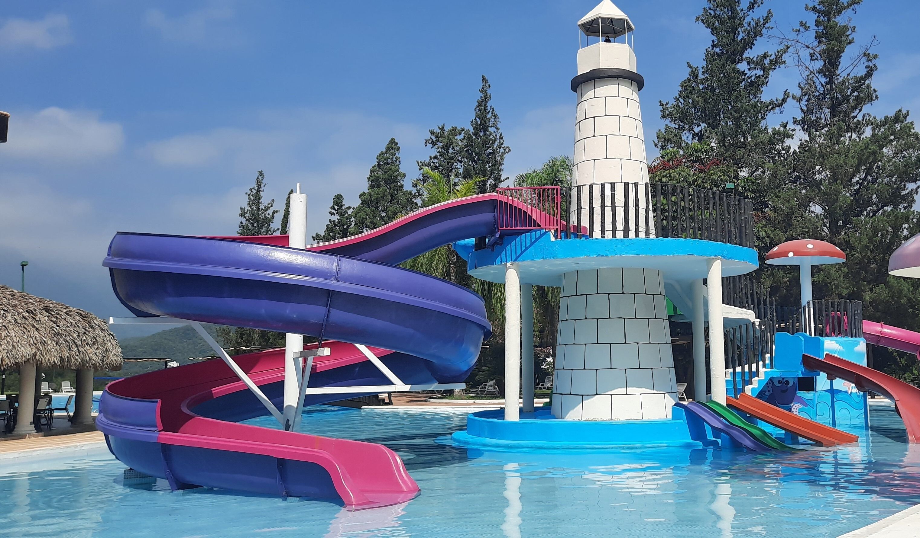 Un parque acuático con múltiples toboganes y una estructura de faro.