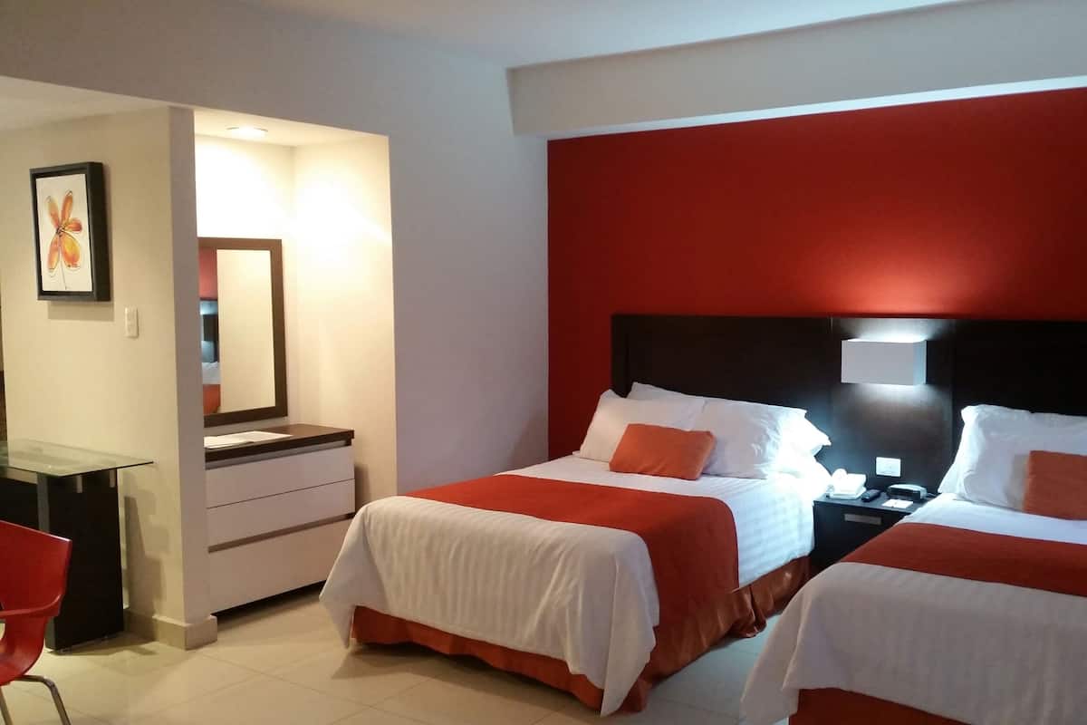 Una habitación de hotel con dos camas, un escritorio y una silla.