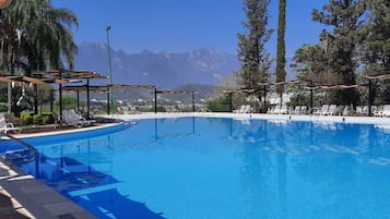 Alberca techada, 3 albercas al aire libre y sombrillas en la alberca