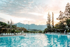 A swimming pool with lounge chairs and a view of mountains in the background. - Bahía Escondida (Santiago)