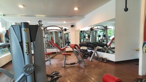 A gym with various exercise equipment, including weight machines and dumbbells.