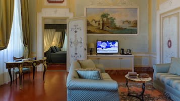 Un salon avec un canapé, un téléviseur et une table.