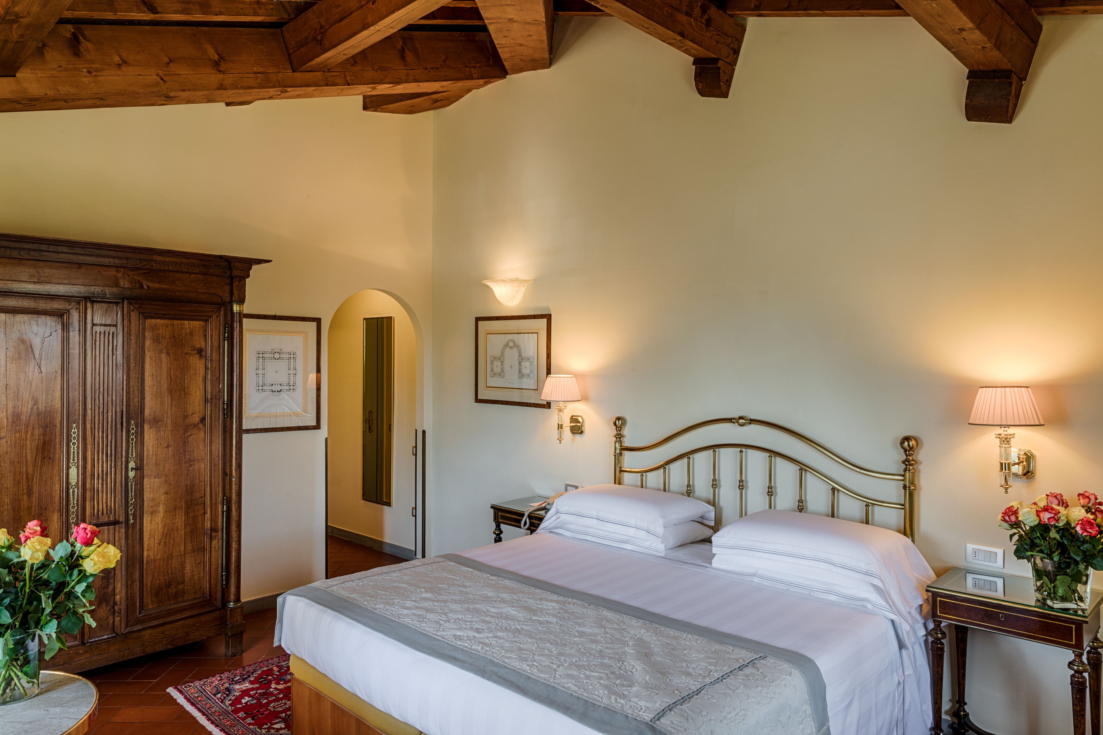 Ein Schlafzimmer mit einem großen Bett, einem Holzschrank und zwei Nachttischlampen.