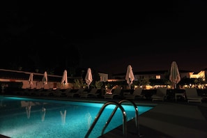 A nighttime pool area with lounge chairs and umbrellas. - Villa Olmi Firenze (Bagno a Ripoli)