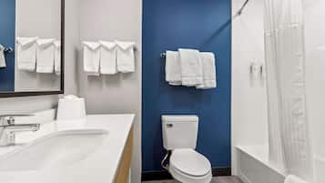 A modern bathroom with a white sink, a toilet, and a shower area.