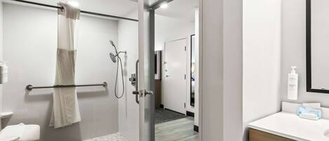Une salle de bain moderne avec une douche à parois de verre, un lavabo blanc et un porte-serviettes.