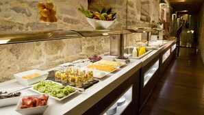 A buffet with various fruits, vegetables, and beverages.