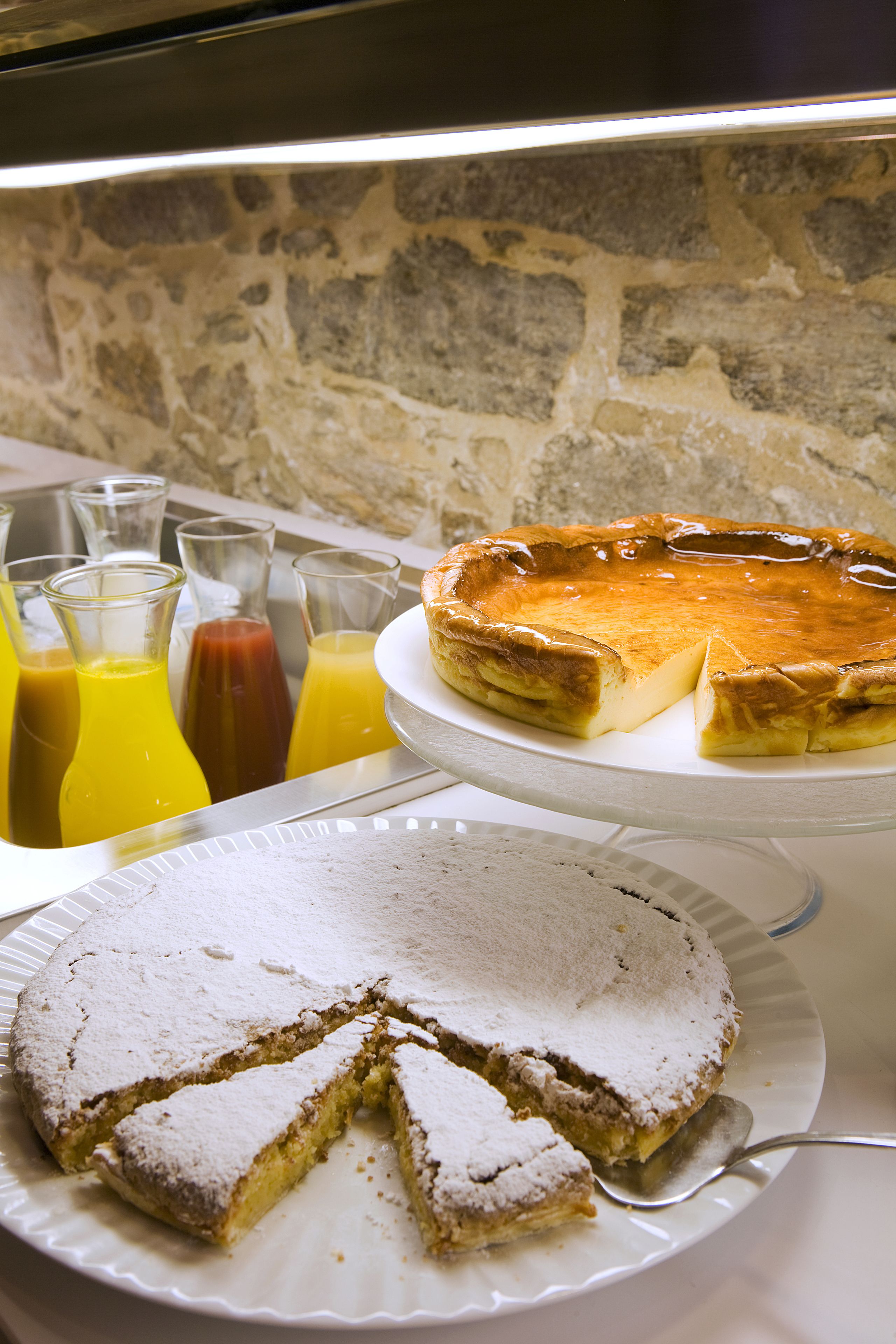 Une présentation de desserts comprenant une tarte, un gâteau et des verres de jus de fruits.