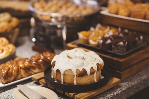 A variety of baked goods including pastries and bread on a wooden board.