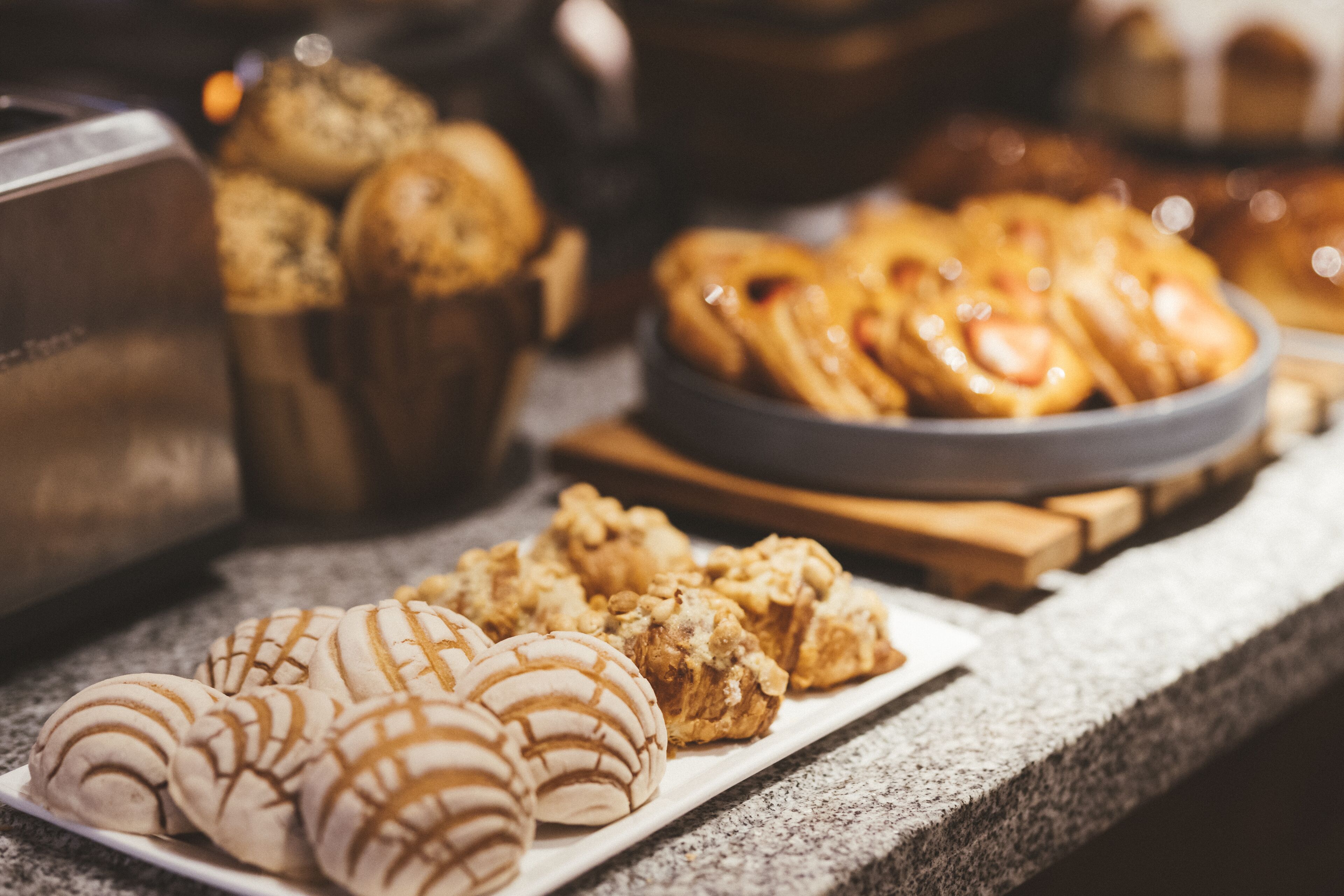 Verschiedene Backwaren auf einer Arbeitsplatte, darunter Croissants und Muffins.