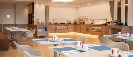A modern hotel dining area with multiple tables, chairs, and a buffet counter.