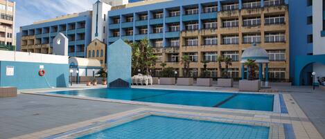 Ein Hotel mit Schwimmbad, mehreren Balkonen und einem modernen architektonischen Design.