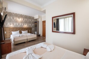 A hotel room with a large bed, a wardrobe, a bedside table, and a mirror. - Golden City Hotel (Athens)