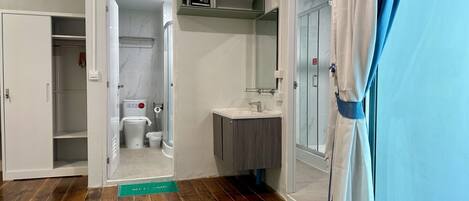 A compact bathroom with a shower, toilet, and sink.