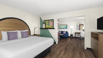 Een hotelkamer met een bed, een bureau, een stoel, een televisie en een bank.