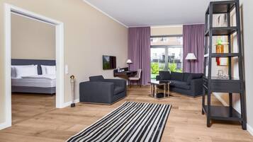 Ein modernes Wohnzimmer mit einem Bett, zwei Sofas, einem Couchtisch und einem Bücherregal.