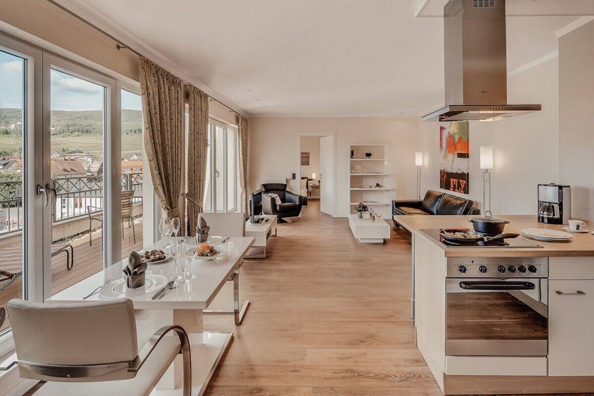 Une cuisine moderne avec un coin repas, de grandes fenêtres et une vue sur la campagne.
