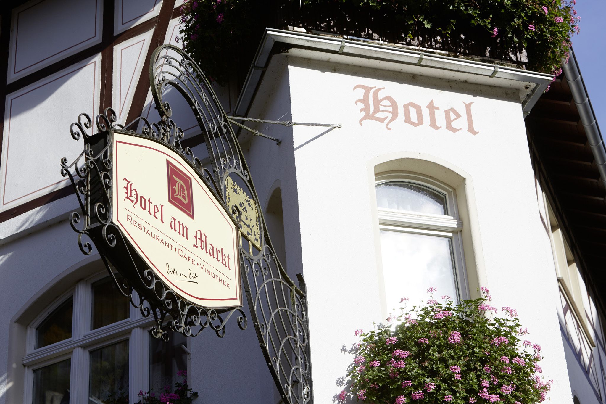 Une enseigne d’hôtel au design traditionnel, comprenant des armoiries et les mots « Hotel am Markt » et « Restaurant, Café ».