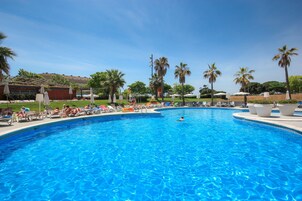 Una piscina al aire libre de temporada, sillones reclinables de piscina