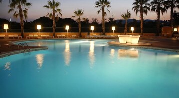 Una piscina al aire libre de temporada, sillones reclinables de piscina