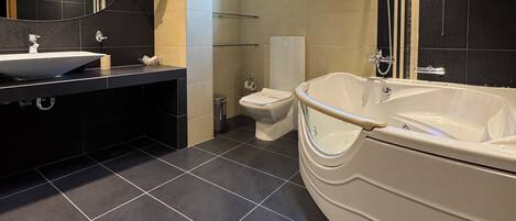 Ein modernes Badezimmer mit einer großen Badewanne, einem Waschbecken und einer Toilette.