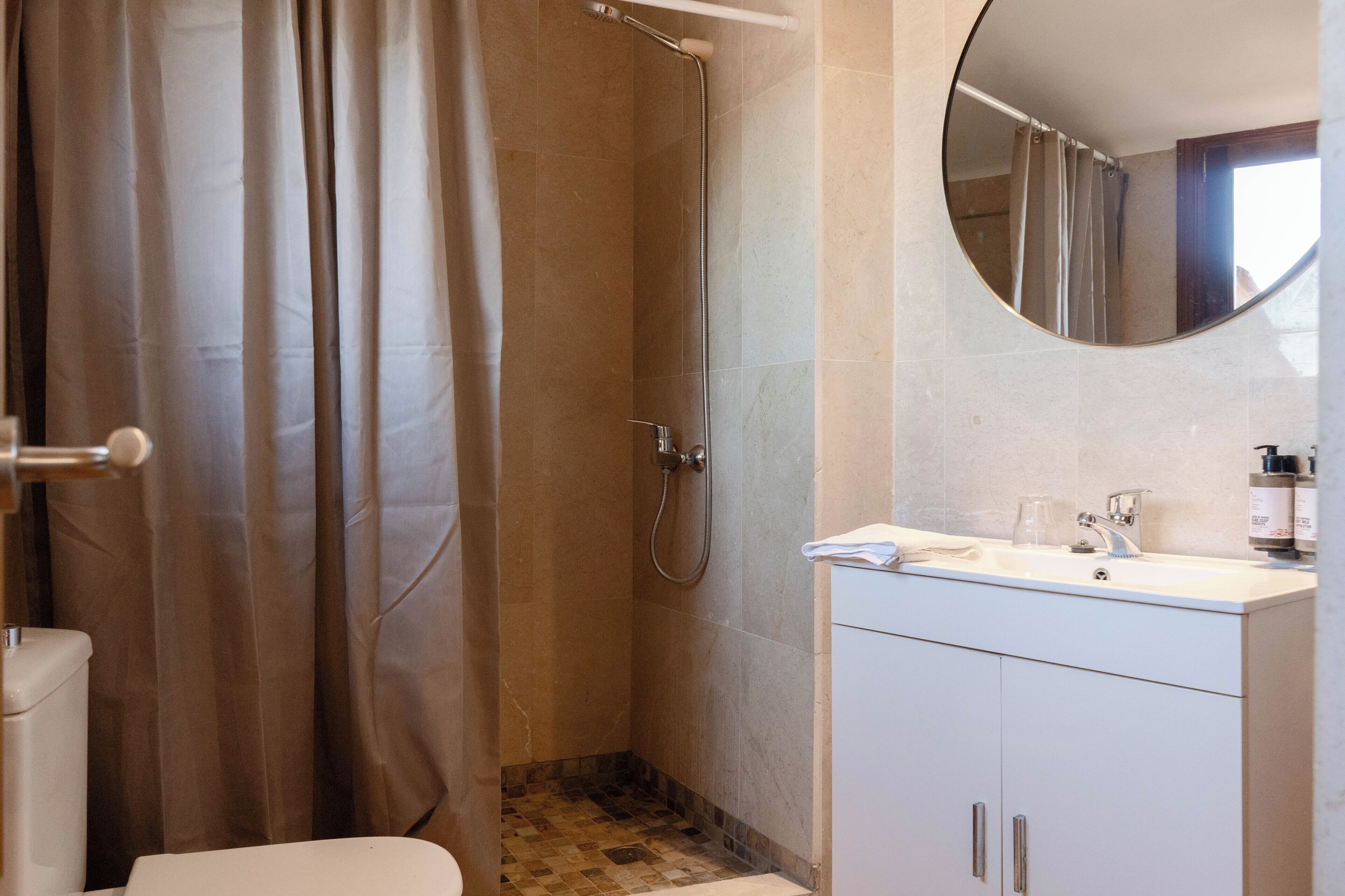 Un baño con ducha, inodoro y lavabo.