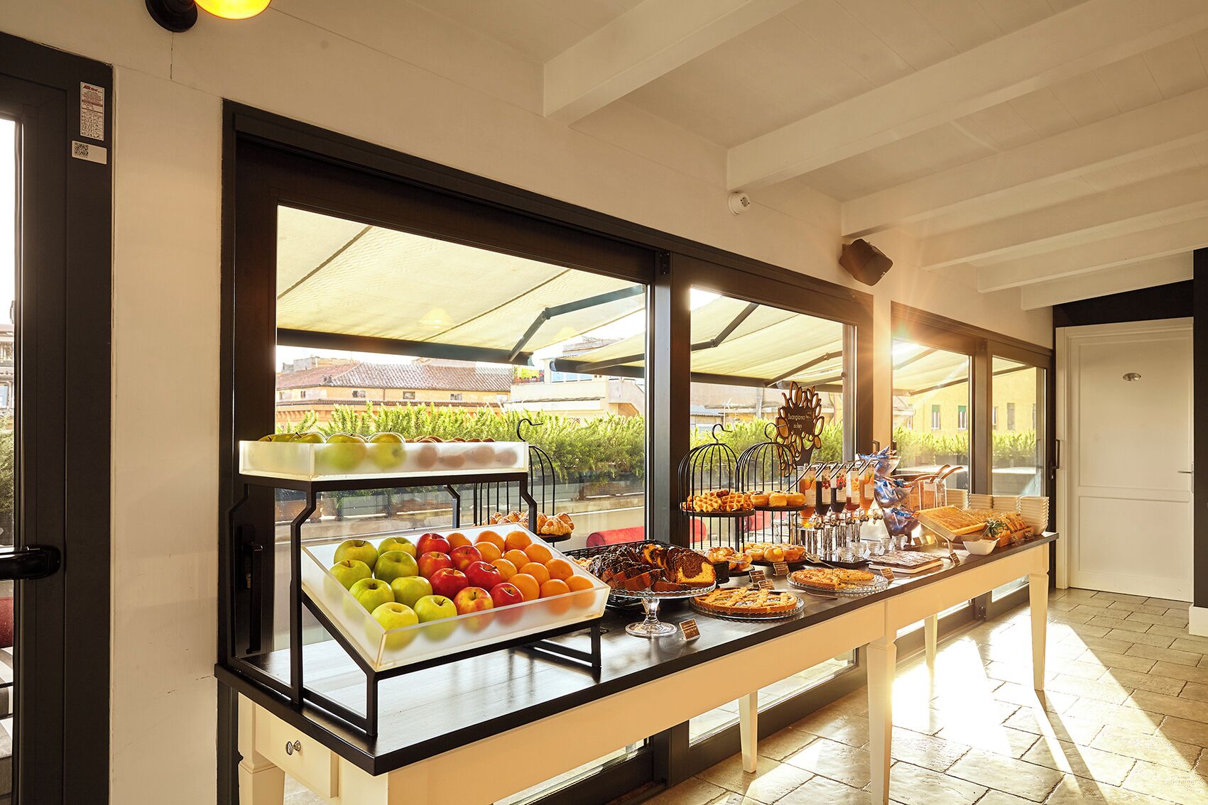 A buffet with various fruits, pastries, and beverages.