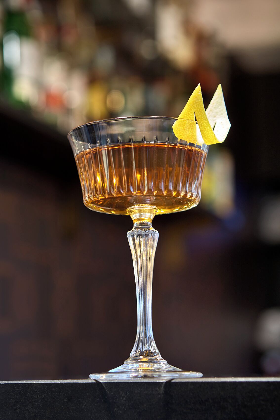 A cocktail in a glass with a stem, placed on a surface.