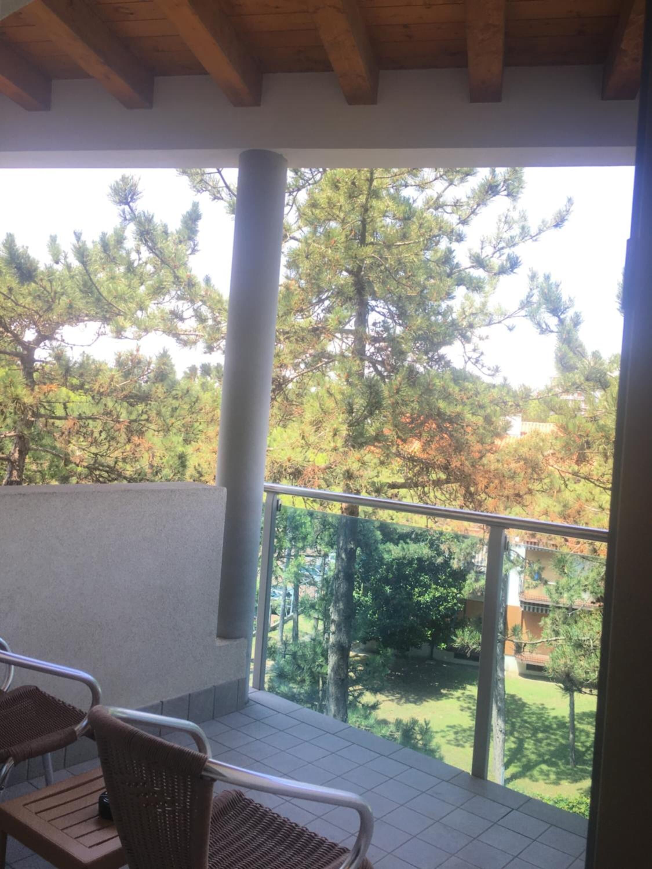 Un balcon donnant sur la verdure, avec un sol carrelé.