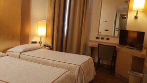 A hotel room with two beds, a desk with a chair, a TV, a telephone, and a mirror. - Hotel Tiffany (Trezzano sul Naviglio)