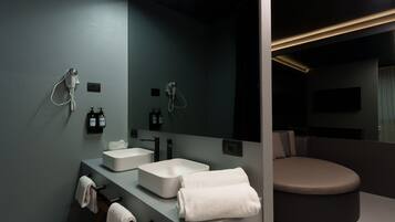 Ein modernes Badezimmer mit zwei Waschbecken, einem großen Spiegel und einer separaten Duschkabine.