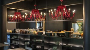 A modern dining area with a buffet setup, including various food items and glassware. - The Aries Hotel (Vicenza)