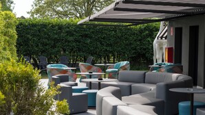 An outdoor seating area with modern furniture and a covered section. - The Aries Hotel (Vicenza)