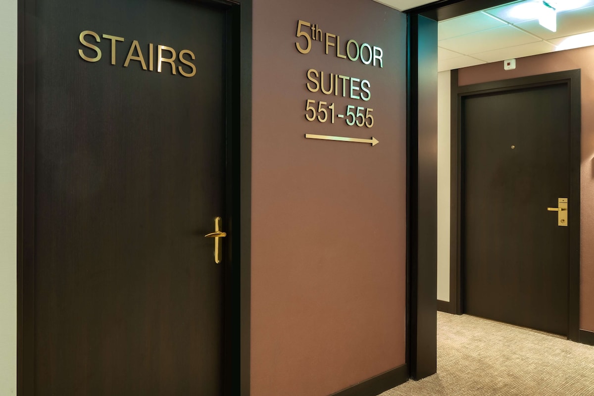 A hallway with doors labeled "STAIRS" and "5th FLOOR SUITES 551-555".