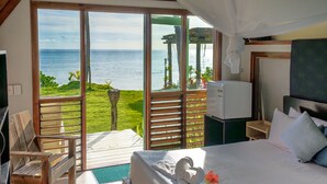 Un dormitorio con una cama grande, televisión, escritorio y vistas al océano.
