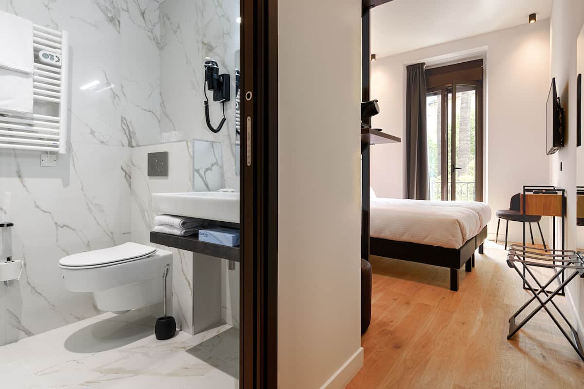 Ein modernes Badezimmer mit Marmorwand, Toilette und Wandhaartrockner.