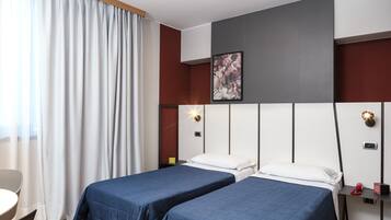 Una habitación de hotel con dos camas, un escritorio y una silla.