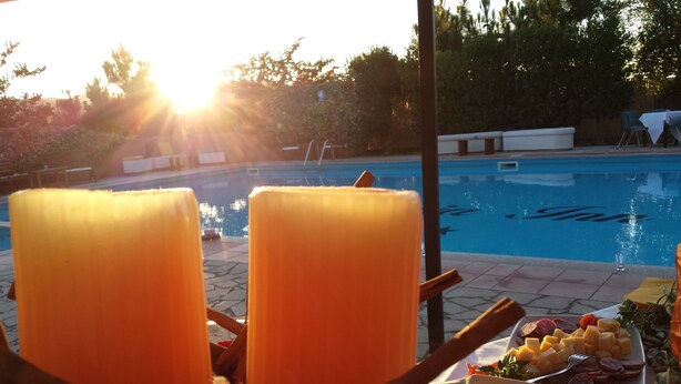 A poolside setting with candles, snacks, and a pool in the background. - Pausania Inn (Tempio Pausania)