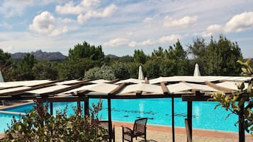 Una piscina al aire libre de temporada, sombrillas